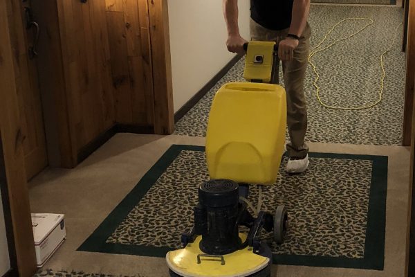 A man is cleaning the floor with a machine.