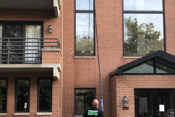 A man is cleaning the windows of an apartment building.