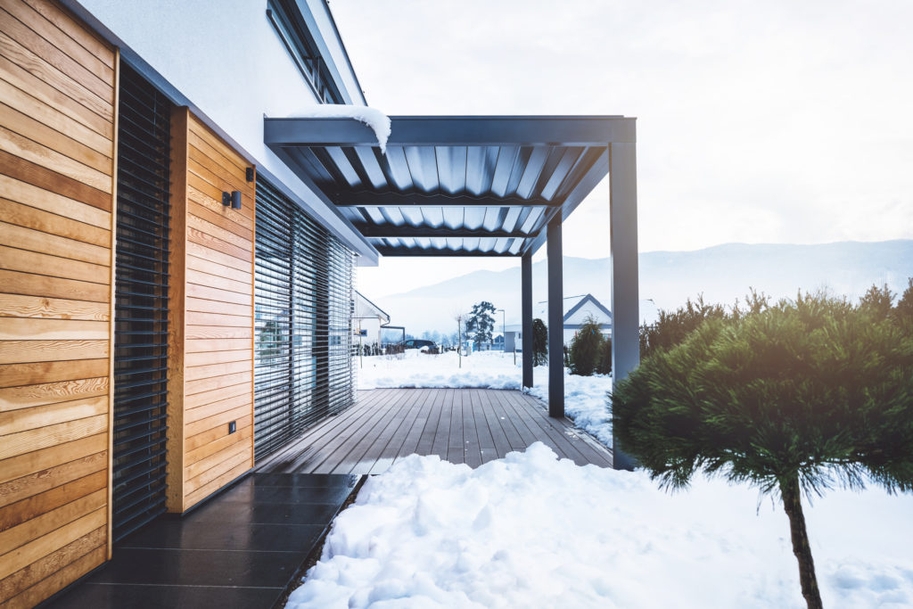 A covered deck with snow on the ground